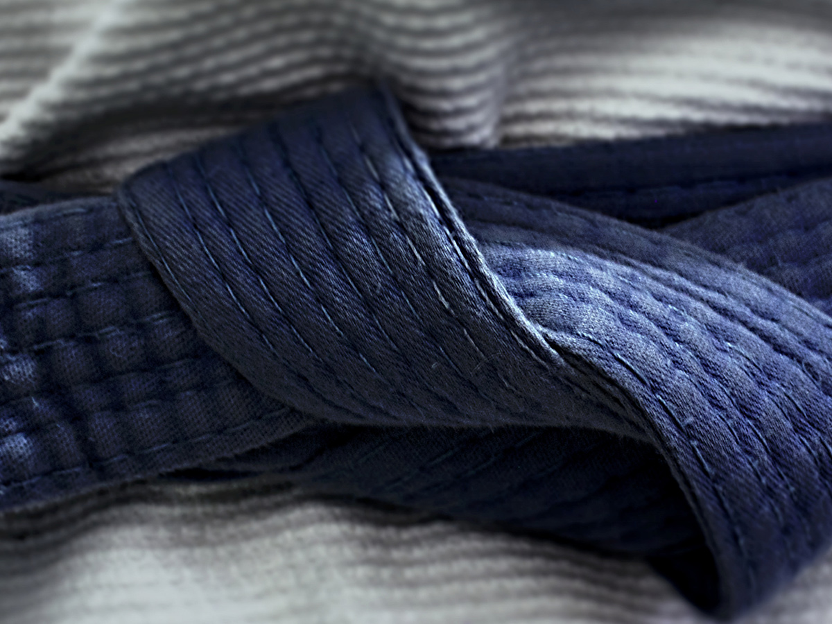 Close up of a Brazilian Jiu-Jitsu blue belt on a white gi.