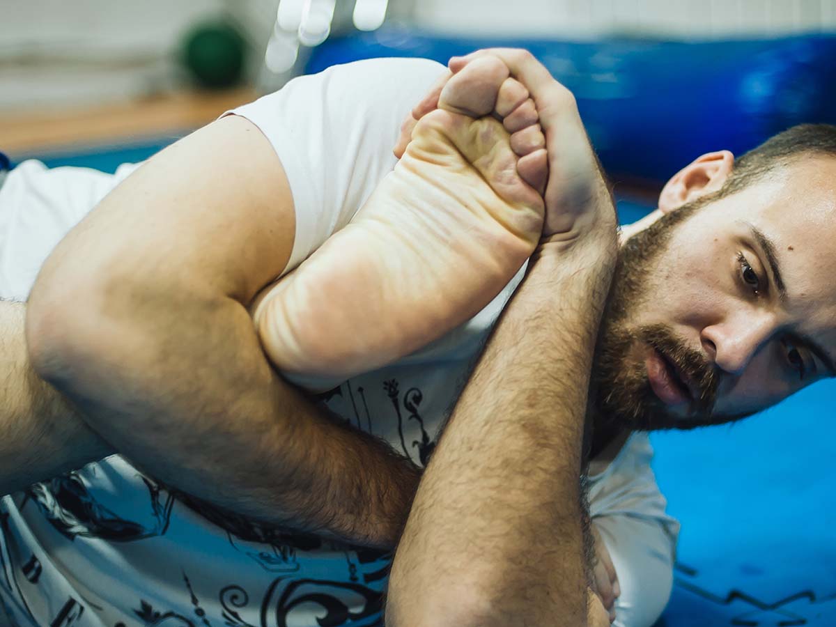 A man holding down another jiu jitsu fighter on a mat